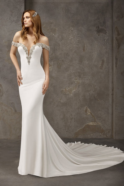 Pronovias Newton is a crepe mermaid dress with a long train, plunging v and off-the-shoulder straps.